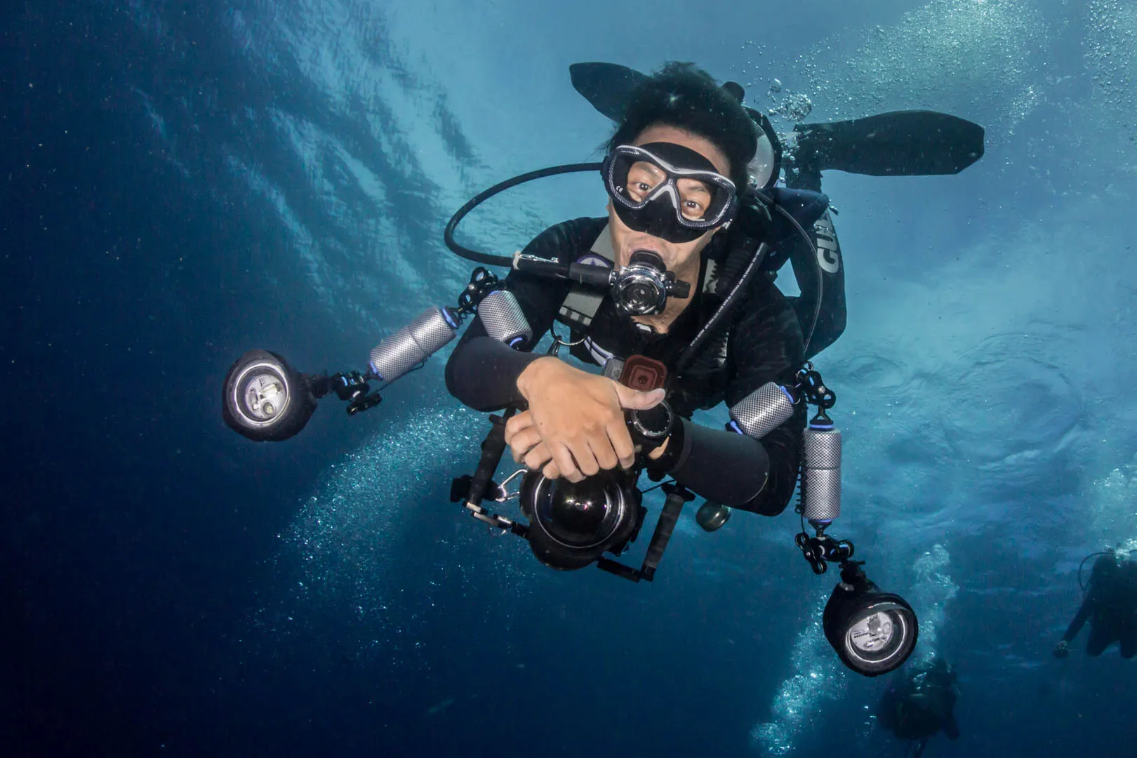Diver with a full equipment set and twin-strobe camera rig