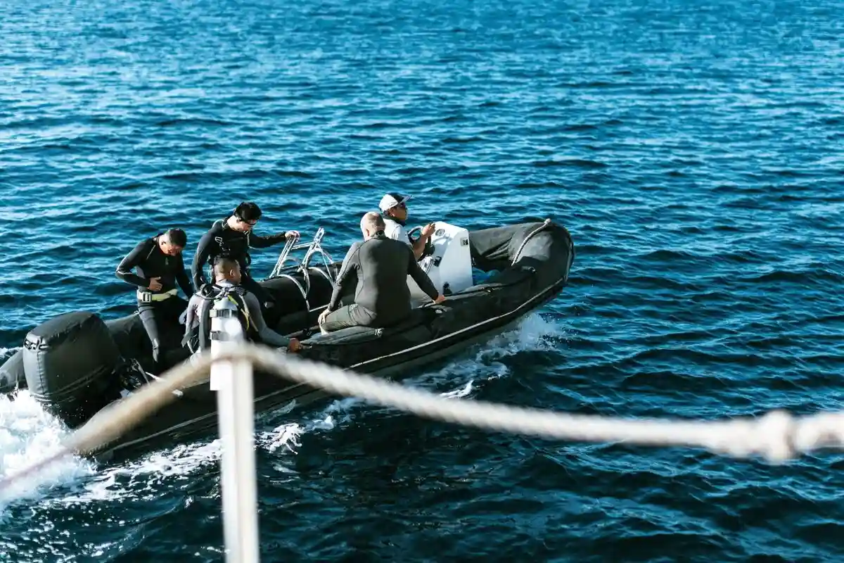 Divers in wetsuits on the tender at the surface