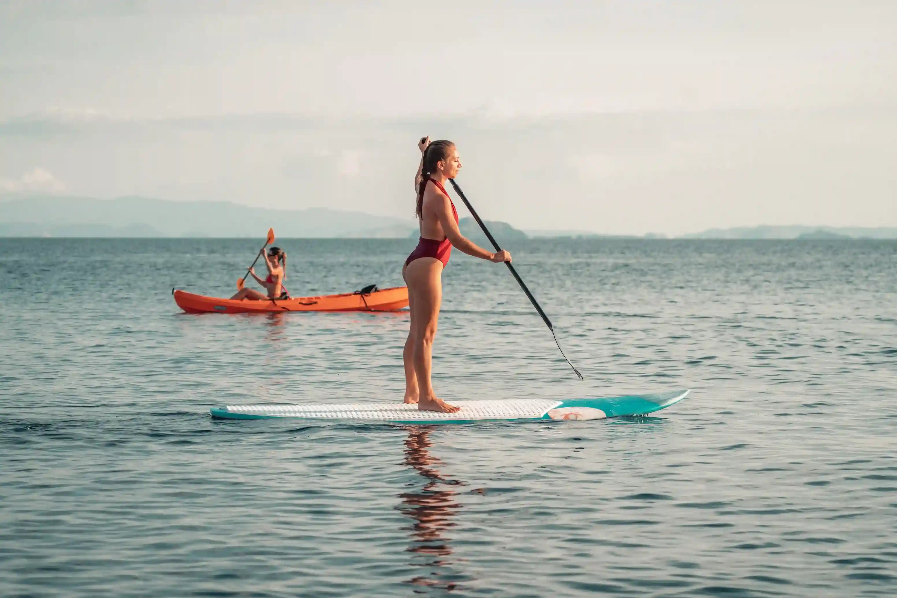 Paddleboarder on mirror-calm water at the islands