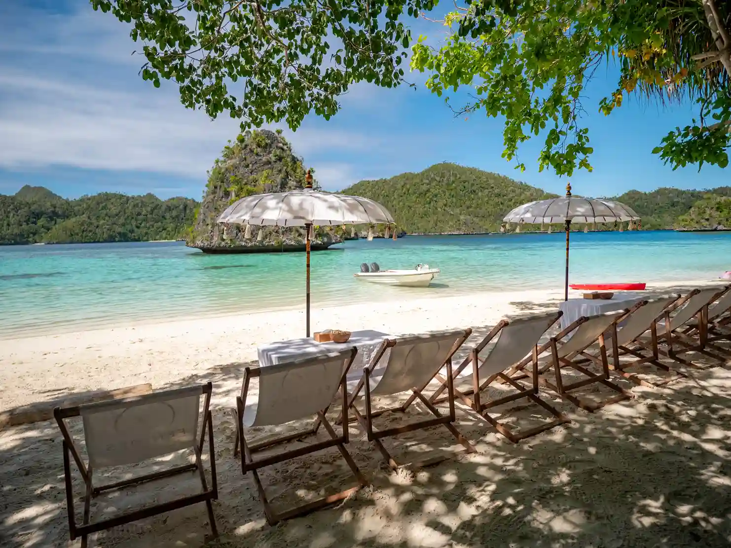 Parasols and deck chairs set out on white sand