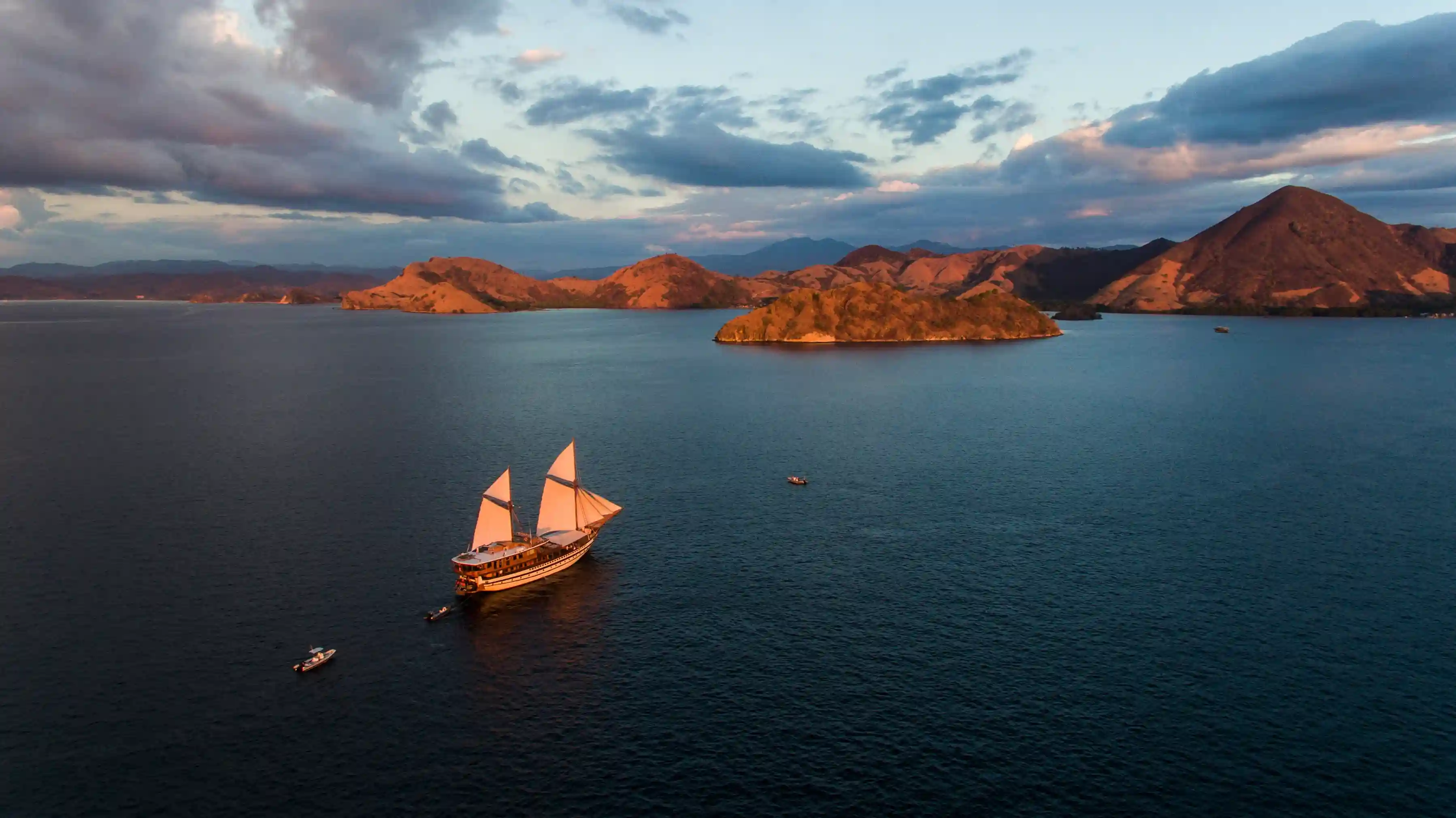 Sailing boat under way between islands at dusk